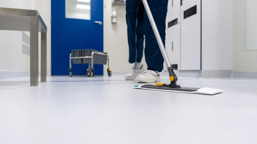 Professionelle Reinigungskraft beim Boden wischen – Hausmeister-Service